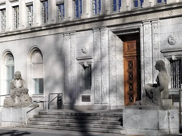 The main entrance of the WTO headquarters — the Centre William Rappard in Geneva; the sculptures “Peace” and “Justice” (1925). Photo: Pierre-Yves Dhinaut / © WTO. Licence: CC BY-SA 3.0. Source: Wikimedia Commons https://commons.wikimedia.org/wiki/File:Cwr_main_entrance.jpg